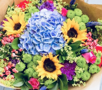 Hello Sunshine - Mixed brightly coloured hand tied bouquet that includes Sunflowers elegantly wrapped in brown paper and raffia