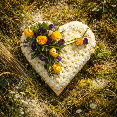 Heart SYM-324 - A white massed heart with yellow and purple spray, designed with love by our floristry team using the freshest flowers available.